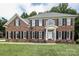 Classic brick two-story home featuring black shutters and a well-manicured lawn at 3015 Rochester Ct, Monroe, NC 28110