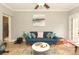 Bright living room features a blue sofa, ceiling fan, and an abstract painting at 3015 Rochester Ct, Monroe, NC 28110