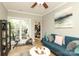 Bright living room features a blue sofa, ceiling fan, tile floors, and art at 3015 Rochester Ct, Monroe, NC 28110