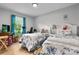 Bright bedroom with twin beds, hardwood floors, large window, and colorful decor at 3545 Yorkland Dr, Hickory, NC 28601