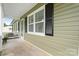 Charming front porch with black shutters, large window, and a storm door at 3545 Yorkland Dr, Hickory, NC 28601