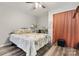 Cozy main bedroom with hardwood floors, ceiling fan, closet with orange curtain and a large floral bedspread at 3545 Yorkland Dr, Hickory, NC 28601