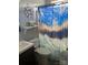Bright bathroom featuring a blue decorative shower curtain, toilet, and floating shelf at 3810 Spike Ln, Vale, NC 28168