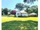 View of the back of the house showing the spacious yard, carport and mature trees at 402 Madison St, Lincolnton, NC 28092