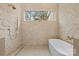Bright bathroom with a textured stone wall and an elegant freestanding tub under a picture window at 4208 Antioch Church Rd # 1, Weddington, NC 28104