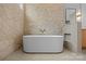 A modern bathroom featuring a chic freestanding tub nestled against a textured stone accent wall at 4208 Antioch Church Rd # 1, Weddington, NC 28104