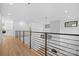Bright upstairs hallway featuring sleek metal railings, hardwood floors, and modern light fixtures at 4208 Antioch Church Rd # 1, Weddington, NC 28104