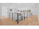 Bright open hallway with modern railings, hardwood floors, and stylish pendant lighting at 4208 Antioch Church Rd # 1, Weddington, NC 28104
