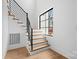Modern staircase with wooden steps, black metal railings, and a large window providing natural light at 4208 Antioch Church Rd # 1, Weddington, NC 28104