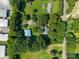 Aerial view of a house and its outbuildings surrounded by mature trees and green grass at 4534 Pebblebrook Sw Cir, Concord, NC 28027