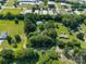 Aerial view of a home surrounded by lush trees, neighboring buildings, and expansive green fields under a clear sky at 4534 Pebblebrook Sw Cir, Concord, NC 28027