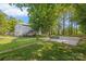 Side view of a house with a backyard featuring a large parking pad and well-kept grassy lawn at 4534 Pebblebrook Sw Cir, Concord, NC 28027