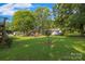 Overhead view of backyard with lush lawn, barbecue area, and trees, great for outdoor activities at 4534 Pebblebrook Sw Cir, Concord, NC 28027