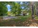 Backyard showing a large paved parking area alongside the residence, with lush trees surrounding the property at 4534 Pebblebrook Sw Cir, Concord, NC 28027