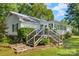 Back exterior featuring a porch with stair access and lush green surroundings at 4534 Pebblebrook Sw Cir, Concord, NC 28027