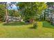 Expansive backyard with well-maintained lawn and covered patio featuring an outdoor kitchen at 4534 Pebblebrook Sw Cir, Concord, NC 28027