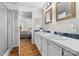Bathroom featuring double vanity, walk-in shower, and wood-look flooring, adjacent to the primary bedroom at 4534 Pebblebrook Sw Cir, Concord, NC 28027