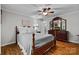 Inviting bedroom with ceiling fan, wood-look floors, and a large, dark wood dresser and mirror at 4534 Pebblebrook Sw Cir, Concord, NC 28027