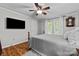 Cozy bedroom with ceiling fan, wood-look floors, and natural light from the white-framed window at 4534 Pebblebrook Sw Cir, Concord, NC 28027
