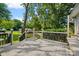 View of the outdoor wooden deck with decorative railings overlooking the backyard and lush greenery at 4534 Pebblebrook Sw Cir, Concord, NC 28027