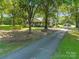 Home with a charming front porch and well-maintained lawn, complemented by mature trees and a long driveway at 4534 Pebblebrook Sw Cir, Concord, NC 28027