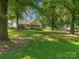 A cozy house with a welcoming front porch, surrounded by lush greenery and mature trees on a sunny day at 4534 Pebblebrook Sw Cir, Concord, NC 28027