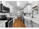 Modern white kitchen with stainless steel appliances and farmhouse sink at 4534 Pebblebrook Sw Cir, Concord, NC 28027