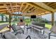 Relaxing outdoor patio area featuring ceiling fan, fireplace, stylish seating, and entertainment at 4534 Pebblebrook Sw Cir, Concord, NC 28027