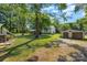 View of the yard showing a residence, barbecue area, outbuildings and lush green space at 4534 Pebblebrook Sw Cir, Concord, NC 28027