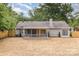 Backyard showcasing a covered patio, mature trees, and a fenced perimeter at 5234 Bellflower Ln, Charlotte, NC 28227