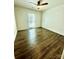 This bedroom boasts gleaming hardwood floors, ceiling fan, and a bright window at 5234 Bellflower Ln, Charlotte, NC 28227