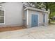 View of the home's side-entry garage with blue doors and concrete driveway at 5234 Bellflower Ln, Charlotte, NC 28227