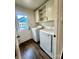 Bright laundry room boasts full-size white washer and dryer, plus storage cabinets at 5234 Bellflower Ln, Charlotte, NC 28227