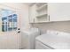 Bright laundry room with white washer and dryer, white cabinetry, and an exterior door at 5234 Bellflower Ln, Charlotte, NC 28227