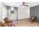 Living room featuring hardwood floors, a grey brick accent wall, and sliding glass doors to the backyard at 5234 Bellflower Ln, Charlotte, NC 28227