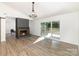 Bright living room featuring a brick fireplace, wood floors, sliding glass doors to the deck at 5234 Bellflower Ln, Charlotte, NC 28227