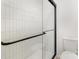Modern shower with white tile, black trim, and a glass door at 5234 Bellflower Ln, Charlotte, NC 28227