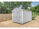 View of the storage shed in the backyard, painted gray with white trim and crossed doors at 5234 Bellflower Ln, Charlotte, NC 28227