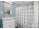 Well-lit bathroom with a marble vanity, a large mirror, and a gray checkered shower curtain at 704 N Main Ave, Newton, NC 28658