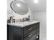 Bathroom vanity boasts marble countertop, black cabinets with gold handles, and unique mirror for added style at 704 N Main Ave, Newton, NC 28658
