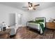 A bright bedroom boasts a black metal bed frame, wood floors, and a view to ensuite bath at 704 N Main Ave, Newton, NC 28658
