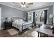 Bright bedroom with hardwood floors, featuring a ceiling fan and lots of natural light from large windows at 704 N Main Ave, Newton, NC 28658