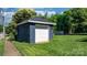 Detached garage with a white door, complemented by the surrounding green lawn at 704 N Main Ave, Newton, NC 28658
