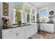 Farmhouse sink with stainless steel appliances and decorative windows offer charming detail to this spacious kitchen at 704 N Main Ave, Newton, NC 28658