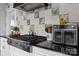 Updated kitchen featuring stainless steel appliances, black countertops, and decorative tile backsplash at 704 N Main Ave, Newton, NC 28658