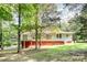 Back of a two story house with a large deck surrounded by lush trees in an expansive backyard at 7154 Woodcock Trl, Stanley, NC 28164