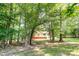 Two story house features a red basement and white siding, nestled amongst a heavily wooded lot at 7154 Woodcock Trl, Stanley, NC 28164