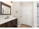 Bathroom featuring wood vanity with white sink and shower at 7154 Woodcock Trl, Stanley, NC 28164