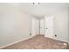 Neutral bedroom showcasing a double door closet and separate entry door at 7154 Woodcock Trl, Stanley, NC 28164
