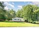 Charming one-story home surrounded by lush trees and a grassy lawn at 7154 Woodcock Trl, Stanley, NC 28164